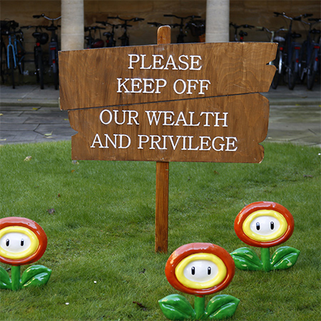 an image of a wooden sign reading 'Please Keep Off our Wealth and Privilege' 
